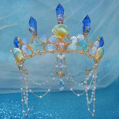 Transform into a mermaid princess with our Crystal Rhinestone Sea Shell Tiara Crown! Handmade with a sturdy metal base and oversized crystal spikes, this tiara comes in multiple variations to suit your mermaid party style. Shine like a star with ocean-themed accents and be the center of attention at your event! material: metal, crystal, beading color: as shown gender: women type: tiara crown Crowns References, Ocean Themed Accessories, Mermaid Visuals, Ocean Crown, Chaumet Tiara, Water Crown, Shell Tiara, Sea Crown, Mermaid Tiara