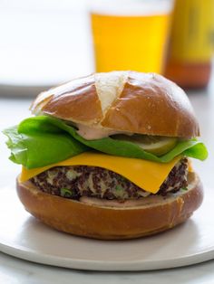 a cheeseburger with lettuce and other toppings on a white plate