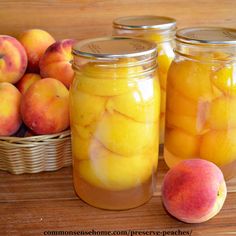 two jars filled with peaches next to baskets of peaches on a wooden table