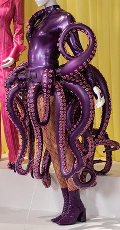 two mannequins dressed in purple and black clothing, one with an octopus costume