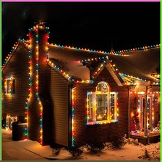 a house covered in christmas lights on the side of it's roof and windows