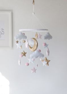 a baby crib mobile with stars, clouds and a crescent hanging from the ceiling