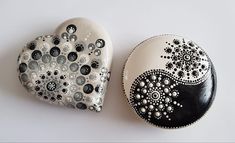 two black and white painted rocks sitting next to each other