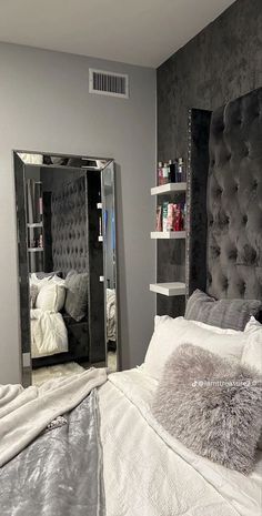 a bedroom with a large mirror on the wall and a bed in front of it