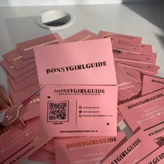 a pile of pink business cards sitting on top of a table