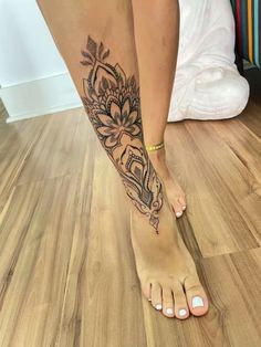 a woman's foot with a tattoo on it, and her leg in the shape of a flower