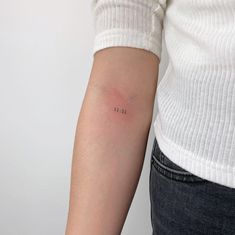 a woman's arm with a small tattoo on the left side of her arm