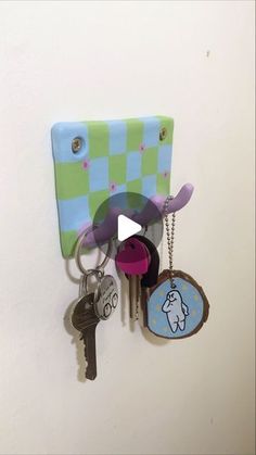 a bunch of keys hanging from a hook on a wall next to a key chain