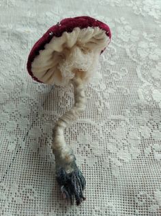 a close up of a small stuffed animal on a table cloth with lace and crochet