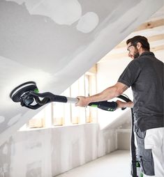 a man is using a paint roller on the ceiling