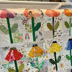 a quilt made to look like flowers and umbrellas