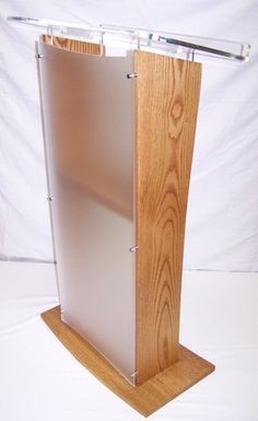 a wooden podium with clear acrylic panels on the front and back sides, standing upright against a white backdrop