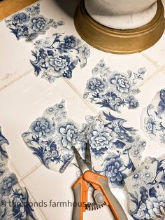 a pair of scissors sitting on top of a table next to blue and white flowers