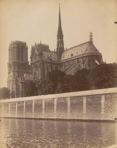 an old black and white photo of a cathedral in the background with water running through it