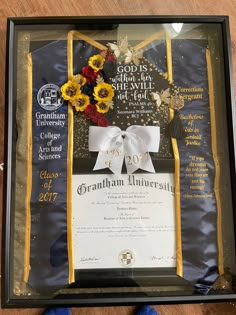 an award plaque with flowers and ribbons on it