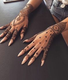 two hands with henna tattoos on them