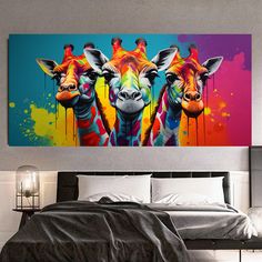 two giraffes painted in bright colors on a wall next to a bed