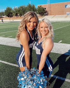 two cheerleaders pose on the football field