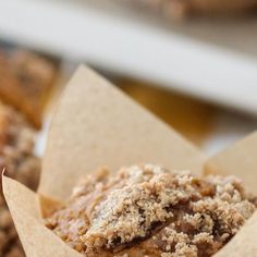 a muffin with crumbs sitting in a paper cup