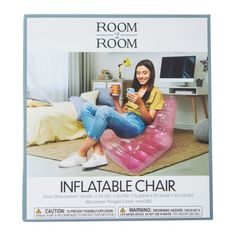 a woman is sitting on an inflatable chair and holding a cup while looking at her cell phone