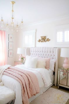 a white and pink bedroom with a chandelier