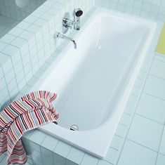 a white bath tub sitting on top of a tiled floor