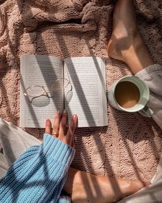 a person is reading a book and drinking coffee