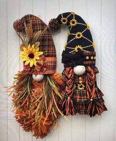 two scarecrows made out of fabric and fake sunflowers are hanging on the wall