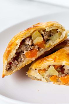 two pastries on a white plate, one with meat and vegetables