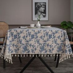 a table with a blue and white floral design on it, next to two chairs