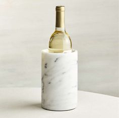 a white marble wine bottle holder with a gold top