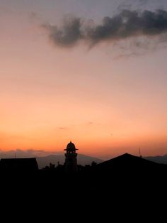 the sky is pink and orange as the sun sets in the distance behind some buildings