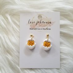 the earrings are on display in front of a white furnishe background with an orange and