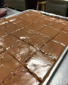 a pan filled with brownies sitting on top of a metal counter next to a pair of red shoes