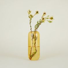 a yellow vase with some flowers in it