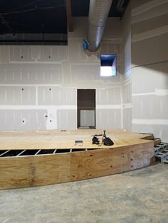 an empty room with unfinished walls and wood flooring in the foreground, under construction