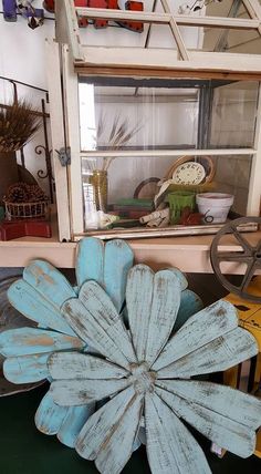 a blue flower sitting on top of a table next to a shelf filled with other items