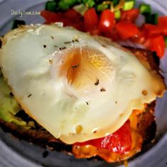 an egg is on top of toast with tomatoes and cucumber in the background