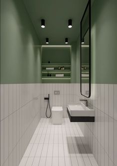 a green and white bathroom with two sinks, mirror, and shower head in it