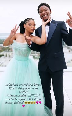 a man in a tuxedo standing next to a woman