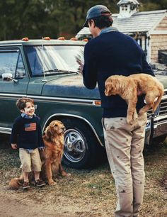 a man standing next to two dogs and a truck