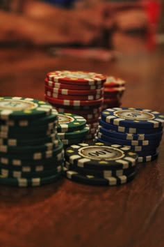 several stacks of poker chips sitting on top of a wooden table next to each other