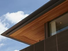 the top of a building with wooden slats on it's sides and sky in the background