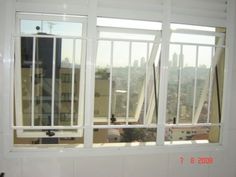 a window with bars on each side and city in the background from an apartment building