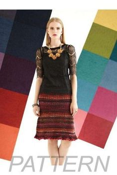 a woman standing in front of a multi colored background wearing a black top and skirt