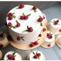 a white cake with raspberries on it