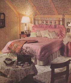 an old fashioned bedroom with pink bedding and floral wallpaper