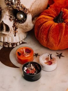 three candles sitting on top of a table next to a skull and other halloween decorations