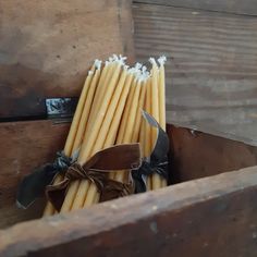 some yellow sticks are in a wooden box