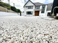 a house with gravel and rocks on the ground in front of it's driveway